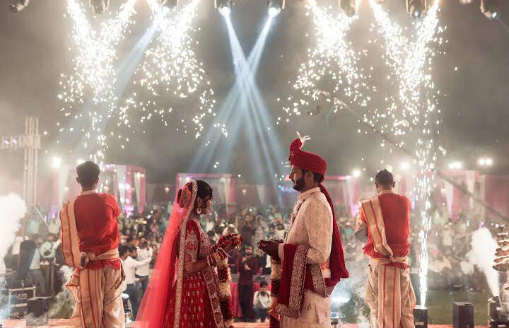 Bride and groom at an evening Wedding Ganga Aarti with pandits and sparkler fountains
